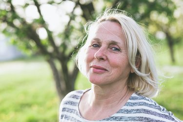 Mittelalte blonde Frau lächelt in die Kamera