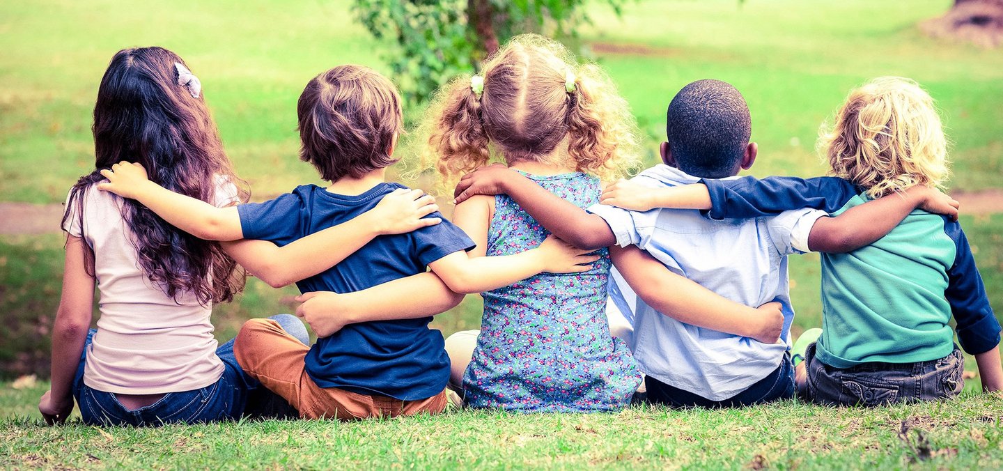 Kindergartenkinder von hinten, die einander umarmen