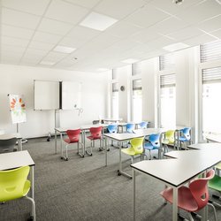 Heller Klassenraum im PSZ Lübeck mit Tischen und bunten Stühlen